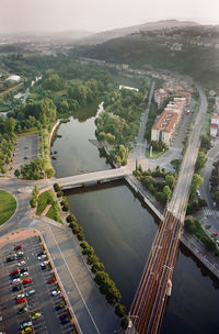 High angle view of city by river against sky