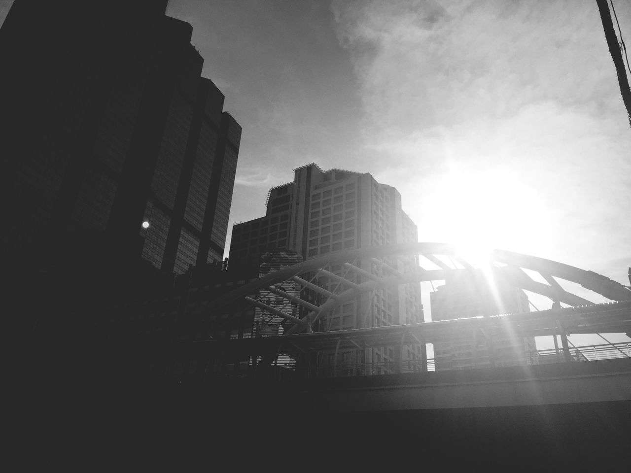 architecture, built structure, building exterior, sun, sunbeam, sky, low angle view, sunlight, lens flare, city, building, cloud - sky, railing, outdoors, modern, day, office building, silhouette, cloud, sunset