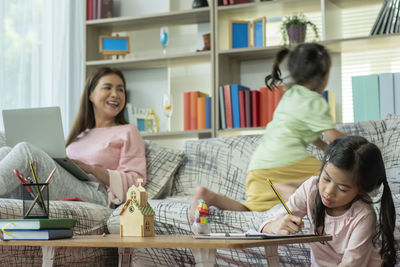 Side view of boy using laptop at home