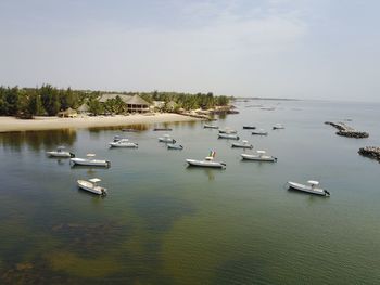 Boats in sea against sky in city