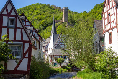 The village monreal with river elz, half-timbered houses and castle loewenburg in the background
