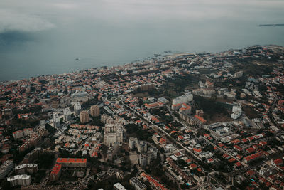 High angle view of townscape by sea against sky