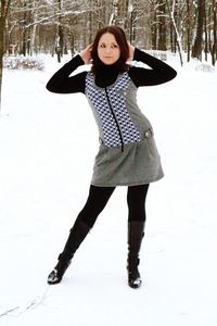 Portrait of smiling young woman standing on snow field