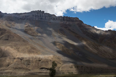 Scenic view of mountain range against cloudy sky