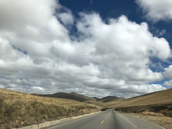 Empty road along countryside landscape