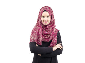 Portrait of young woman standing against white background