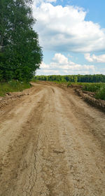 Road amidst field against sky