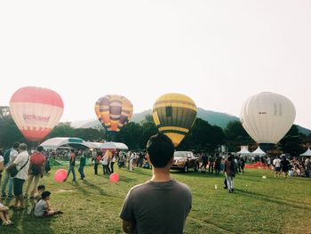 People in hot air balloons against sky