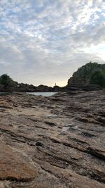 Surface level of rocks on shore against sky