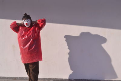 Full length of man standing on red wall