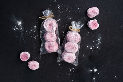 High angle view of pink roses on table against black background