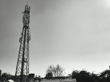 Silhouette of electricity pylon against sky