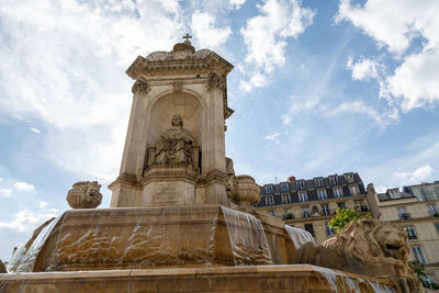 Low angle view of saint-sulpice fountain cloudy sky