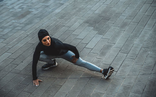 High angle view of woman exercising on footpath