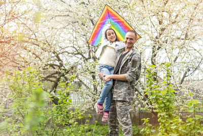 Handsome soldier reunited with family on a sunny day.