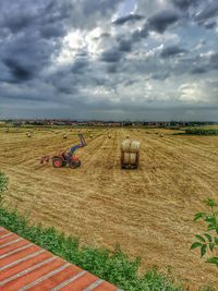 Scenic view of field against cloudy sky