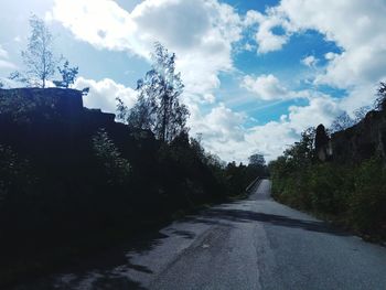 Road amidst trees against sky