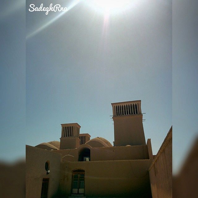 architecture, built structure, building exterior, low angle view, religion, spirituality, place of worship, clear sky, church, sunlight, no people, day, copy space, cross, outdoors, wall - building feature, sky, high section