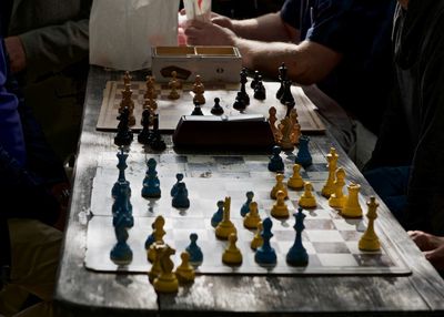 Side view of man playing on chess board