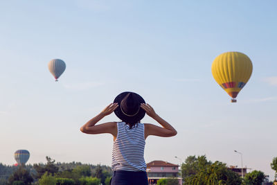 Woman in a striped t-shirt and hat stands in pamukkale and looks