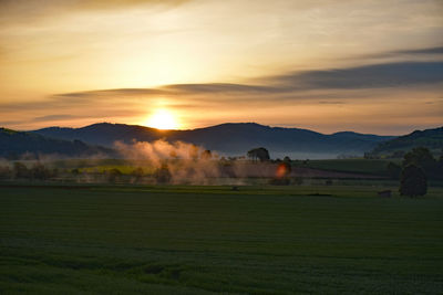 Scenic view of field against sky during sunset