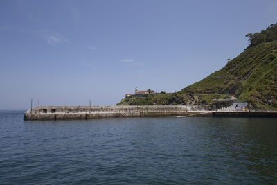 Scenic view of sea by buildings against sky