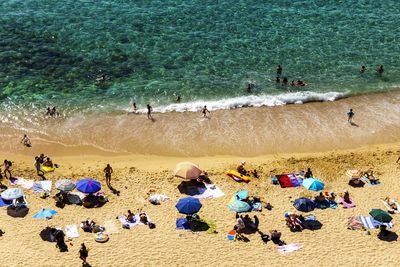 High angle view of people enjoying at beach on sunny day