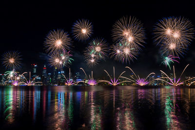 Firework display over river at night