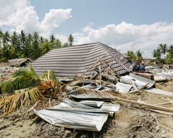 Stack of abandoned building on field against sky