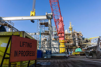 Signboard 'lifting in progress' on a construction work barge at offshore oil field