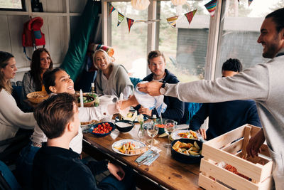 Young man passing towel to friend during lunch party