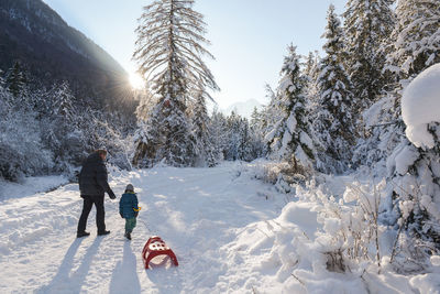 People on snow covered mountain against sky