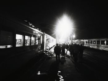 People walking on illuminated street at night