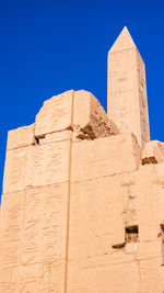 Low angle view of old ruins against clear blue sky