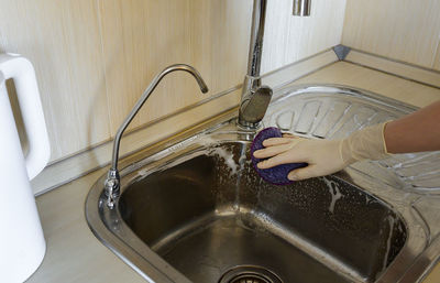 Cropped image of person washing machine part