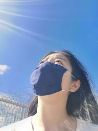 Low angle view of woman against blue sky