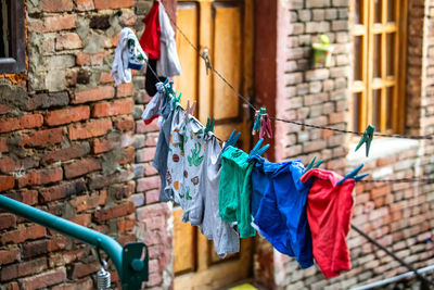 Clothes drying on clothesline against brick wall