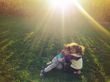 Portrait of cute boy playing on grassy field during sunny day