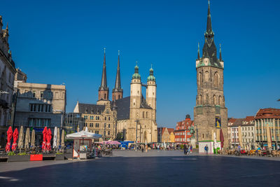 View of buildings in city against blue sky