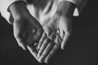 Directly above shot of woman holding ring in hand in darkroom