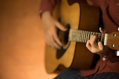 Midsection of woman playing guitar