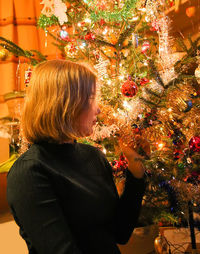 Midsection of woman with christmas tree