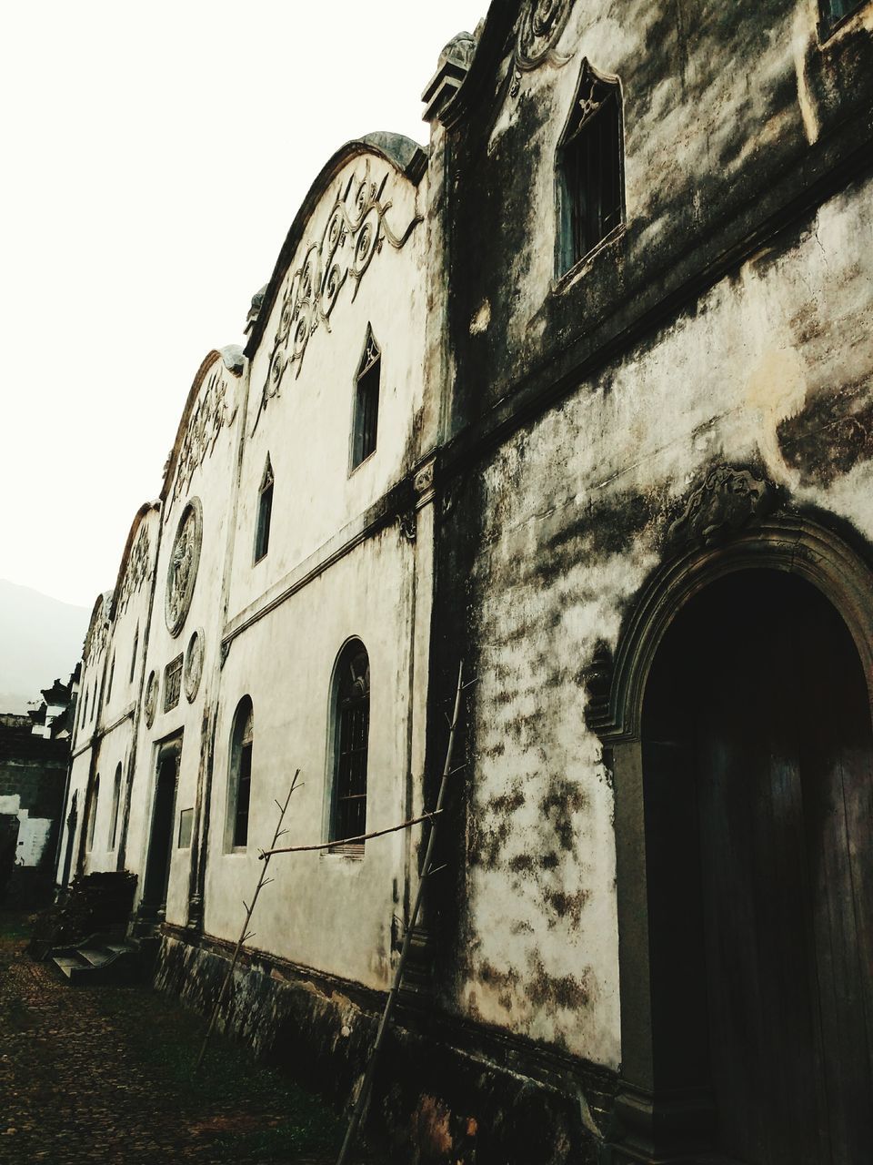 architecture, built structure, building exterior, arch, low angle view, window, old, building, abandoned, sky, history, day, outdoors, wall - building feature, weathered, no people, clear sky, facade, damaged, exterior