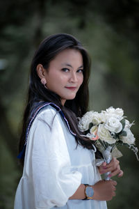 Portrait of young woman with bouquet