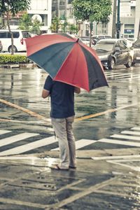 Rear view of woman walking with umbrella