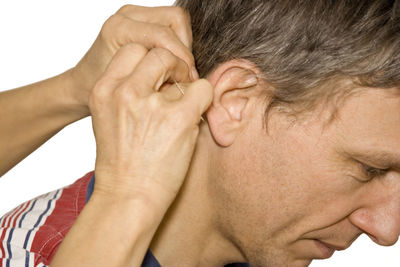 Cropped image of hand applying acupuncture needle on man neck