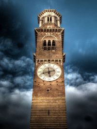 Low angle view of clock tower against cloudy sky