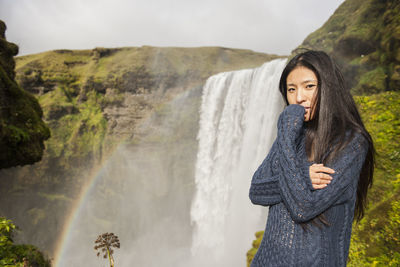 Beautiful woman posing at skogarfoss waterfall in iceland