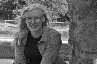 Portrait of a smiling young woman sitting outdoors