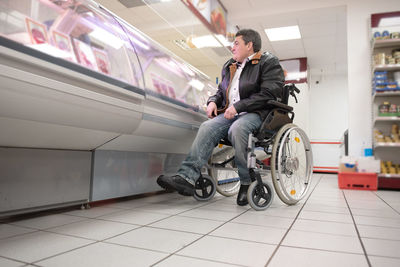 A disabled person in a wheelchair buys groceries